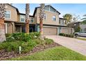 Tan two-story townhome with palm trees and a brick driveway at 28523 Pleasant Bay Loop, Wesley Chapel, FL 33543