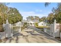 White house with gated entrance and long driveway at 31445 Amberlea Rd, Dade City, FL 33523