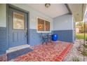 Front porch with terracotta tile flooring and a small bistro set at 3282 Honeysuckle Rd, Largo, FL 33770