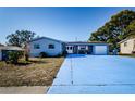 Ranch style home with brick entryway, attached garage, and large driveway at 4573 Deltona Blvd, Spring Hill, FL 34606