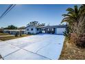 Front view of a ranch home with a large blue driveway at 4573 Deltona Blvd, Spring Hill, FL 34606