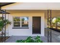 Dark brown front door and a window, with white walls at 5219 E 17Th Ave, Tampa, FL 33619