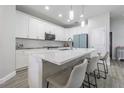 Modern kitchen with white cabinets, quartz countertops, and island seating at 8510 Dee Cir, Riverview, FL 33569