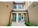 Townhome entry with teal doors, tile flooring, and flanking windows at 11536 Crowned Sparrow Ln, Tampa, FL 33626