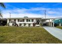 Ranch home with carport and a spacious front yard at 1205 Chevy Chase Dr, Sun City Center, FL 33573