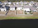 Aerial view of houses with solar panels and a pond at 16719 Delia St, Wimauma, FL 33598