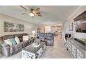 Spacious living room with gray sectional sofa and large TV at 31428 Briars Ml, San Antonio, FL 33576