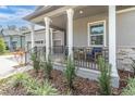 Covered front porch with seating area, metal railing, and landscaping at 4661 Southern Valley Loop, Brooksville, FL 34601