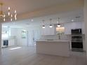 Open concept kitchen with island, white cabinets and high end finishes at 10322 N Oakleaf Ave, Tampa, FL 33612