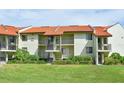 Condo building exterior with Spanish tile roofs and landscaping at 1515 Pinellas Bayway S # 70, Tierra Verde, FL 33715