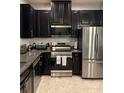 Modern kitchen features stainless steel appliances, granite countertops, and dark cabinetry at 5153 Bay Isle Cir, Clearwater, FL 33760