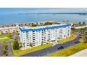 Aerial view of waterfront community with multiple buildings, pool, and tennis courts at 7 Elgin Pl # 812, Dunedin, FL 34698