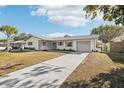 Front view of a renovated house with a gray driveway at 10904 90Th Ter, Seminole, FL 33772