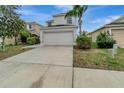 Two-story house with white siding, two-car garage, and a driveway at 1107 Seminole Sky Dr, Ruskin, FL 33570