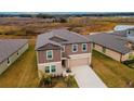 Two-story house with brown siding, beige garage door, and landscaping at 11307 Linden Depot Rd, San Antonio, FL 33576