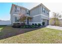 Two story house with gray siding, solar panels, and a two car garage at 11514 Brighton Knoll Loop, Riverview, FL 33579