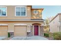 Two-story tan house with two-car garage and burgundy front door at 11814 Castine St, New Port Richey, FL 34654