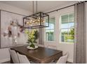 Elegant dining area with large windows, a modern chandelier, and neutral decor at 12144 Cattleside Dr, Riverview, FL 33579