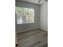 Spacious bedroom with wood-look flooring and large window at 18001 Richmond Place Dr # 125, Tampa, FL 33647