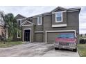 Two-story house with gray siding, two-car garage, and landscaping at 2420 Allegheny Valley St, Ruskin, FL 33570