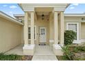 Front entry with columns, a white door, and a covered porch at 6406 S Richard Ave, Tampa, FL 33616