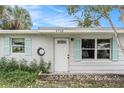 Front entrance of a ranch home featuring a white door and light brick exterior at 6702 Sandra Dr, Port Richey, FL 34668