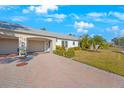 Side view of a villa with a two-car garage and well-maintained lawn at 8403 Annwood Rd, Seminole, FL 33777