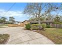 House with a curved driveway, landscaping, and a large tree in front at 8517 Horizon Ln, Hudson, FL 34667