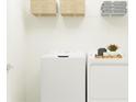 Bright laundry room with washer, dryer, and wire shelving at 10143 Gentle Rain Dr, Land O Lakes, FL 34638