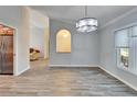 Open dining room with gray walls, wood-look tile floors and a view of the kitchen at 1702 Horseshoe Dr, Plant City, FL 33566