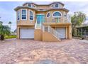 Tan two-story house with white trim, two-car garage, and a brick driveway at 4178 Des Prez Ct, Hernando Beach, FL 34607
