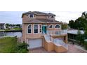 Tan two-story house with white trim, two-car garage, and a brick driveway at 4178 Des Prez Ct, Hernando Beach, FL 34607