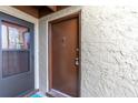 Condo building entrance with brown door and screen door at 4215 E Bay Dr # 1702A, Clearwater, FL 33764
