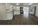 Modern kitchen with white cabinets, stainless steel appliances, and wood-look floors at 7318 Dianne Dr, New Port Richey, FL 34652