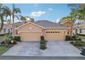 Front view of a tan house with a double garage at 1141 Jameson Greens Dr # 3, Sun City Center, FL 33573