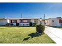 Ranch-style home with carport and landscaped lawn at 1518 Chevy Chase Dr, Sun City Center, FL 33573