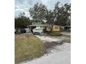 Yellow ranch home with a boat on a trailer in the driveway at 2916 W Ellis Dr, Tampa, FL 33611