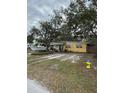 Yellow ranch home with a large yard and fire hydrant at 2916 W Ellis Dr, Tampa, FL 33611