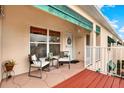 Inviting entryway with a red-stained deck and seating area, creating a welcoming atmosphere at 6363 99Th N Way # 12A, St Petersburg, FL 33708