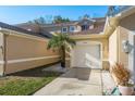 Tan townhome with white garage door, palm tree, and walkway at 8907 Casablanca Way, Tampa, FL 33626