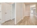 Bright hallway with wood-look tile flooring and white doors at 13278 Ogden Glade Rd, Dade City, FL 33525