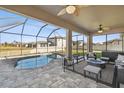 Inviting pool area with covered patio, comfortable seating, and fire pit at 18241 Romanesque Ct, Spring Hill, FL 34610