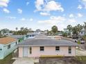 Pink single story home with gray roof, landscaping, and a small yard at 306 180Th E Ave, Redington Shores, FL 33708