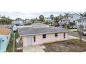 Pink single story home with gray roof, landscaping, and a small yard at 306 180Th E Ave, Redington Shores, FL 33708