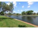 Scenic waterfront view with lush landscaping and a tranquil fountain at 4366 Summersun Dr, New Port Richey, FL 34652