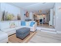Bright living room with white sectional sofa, blue pillows, and a view into the kitchen at 12482 Capri N Cir # 4, Treasure Island, FL 33706