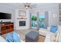 Living room with white sectional sofa, fireplace, and balcony access with water views at 12482 Capri N Cir # 4, Treasure Island, FL 33706
