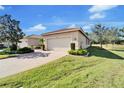 Front view of a lovely house with a two-car garage and manicured lawn at 15618 Aurora Lake Cir, Wimauma, FL 33598
