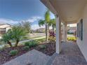 Brick paved porch with tropical landscaping and view of the street at 16931 Scuba Crest St, Wimauma, FL 33598