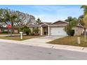 House exterior with a white garage door and mature landscaping at 1700 Hibiscus N Cir, Oldsmar, FL 34677